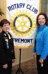 Image of a woman wearing a blue suit standing next to a woman wearing a black suit.