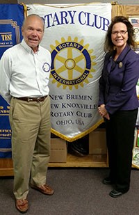 Image of a  woman wearing a blue suit standing next to a man wearing a white dress shirt and khaki pants.