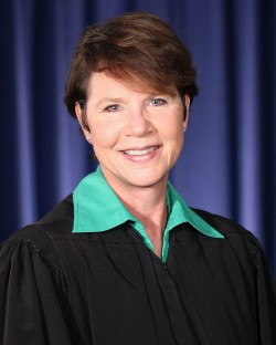 Image of a woman wearing a black judicial robe and a green blouse.
